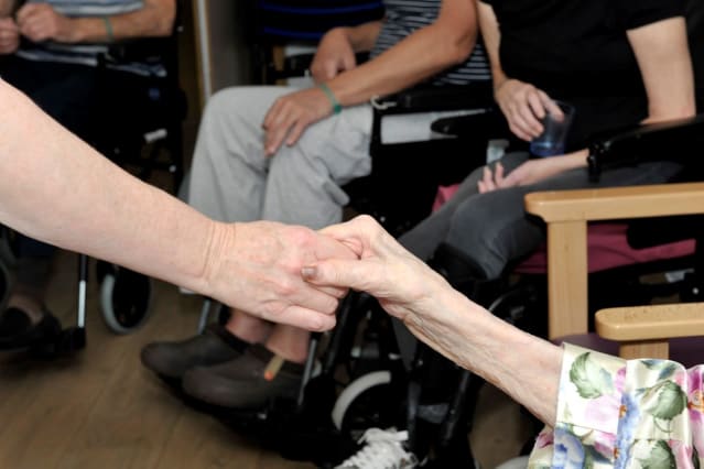 Two people holding hands during a Rubicon Stroke Rehabilitation session.